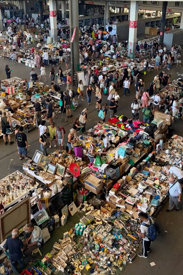 A vast indoor flea market hall packed with stalls and shoppers